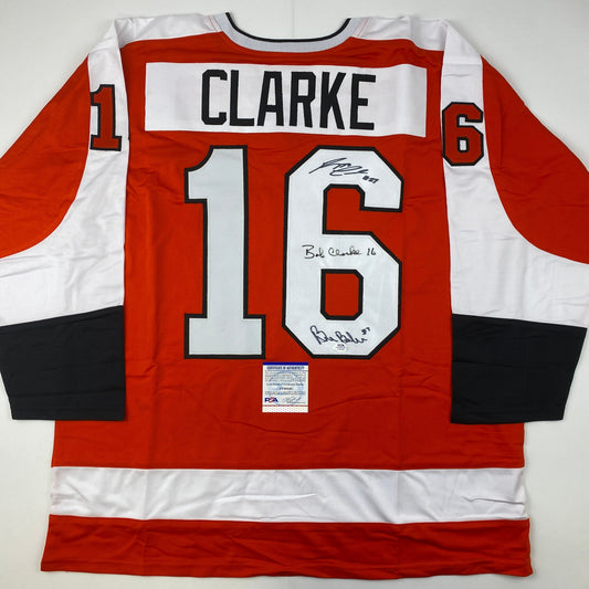 Autographed/Signed Reggie Leach, Bobby Clarke & Bill Barber Philadelphia Orange Hockey Jersey PSA/DNA COA
